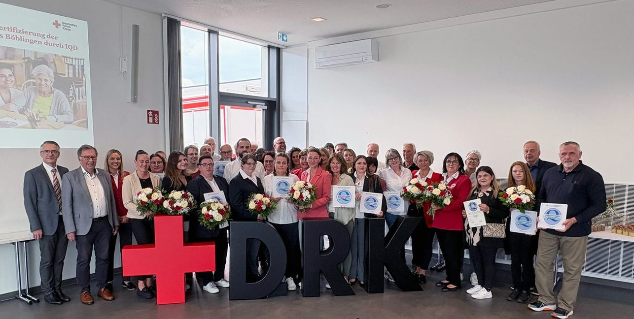 Ein Teil der Mitarbeitenden der 11 DRK-Altenpflegeheime zusammen mit (von links) IQD-Geschäftsführer Gregor Vogelmann und Michael Steindorfner, Präsident des DRK-Kreisverbandes Böblingen e.V.