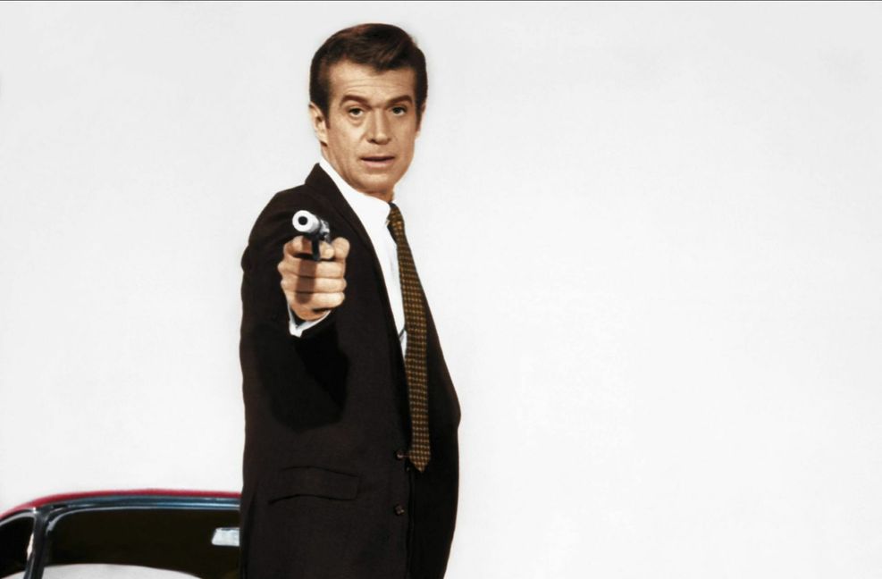 In Deutschland erlangte der E-Type als Dienstwagen des fiktiven FBI-Agenten Jerry Cotton größere Bekanntheit. Schauspieler George Nader in der Rolle des Titelhelden fuhr in den zwischen 1965 und 1969 gedrehten Verfilmungen ein rotes Modell. Foto: imago images/Mary Evans