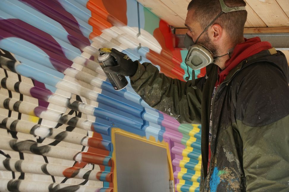 Sprayer Marco Billmaier in Aktion an der Wand des WC-Gebäudes am Ratsplatz Sommerhofen. Bilder: Dettenmeyer