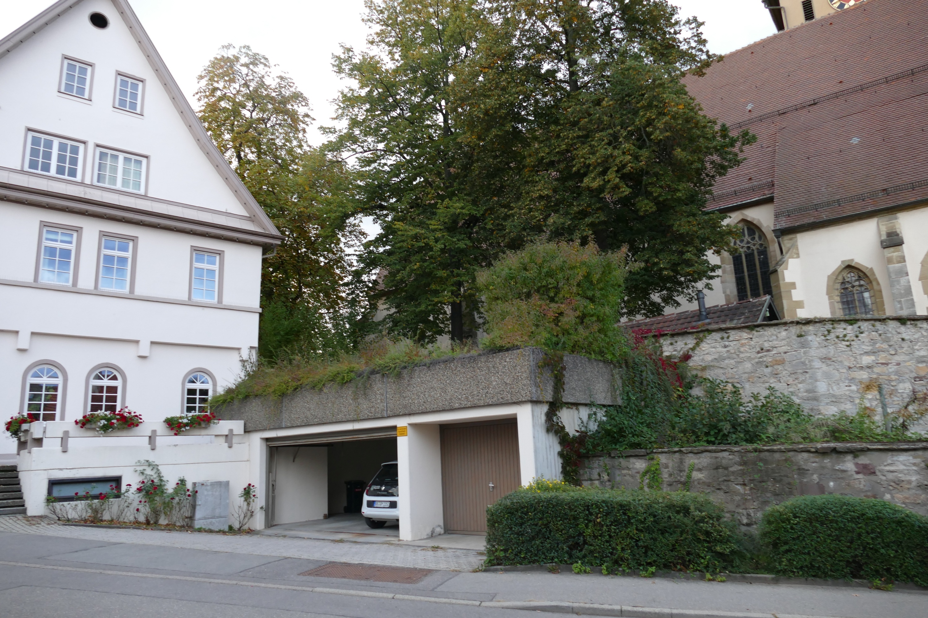 Die Garage soll auf Breite der Kirchhofmauer zurückgebaut und mit Holz verkleidet werden. Bild: Lück