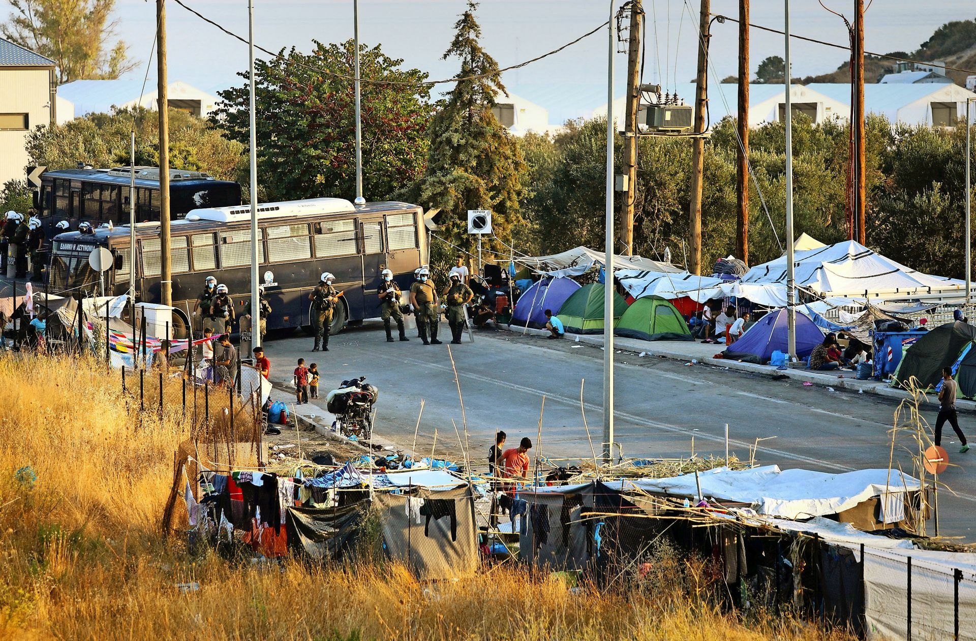Vor dem Abtransport: die griechische Polizei sperrt die Straße aus dem Lager Moria mit Bussen ab.