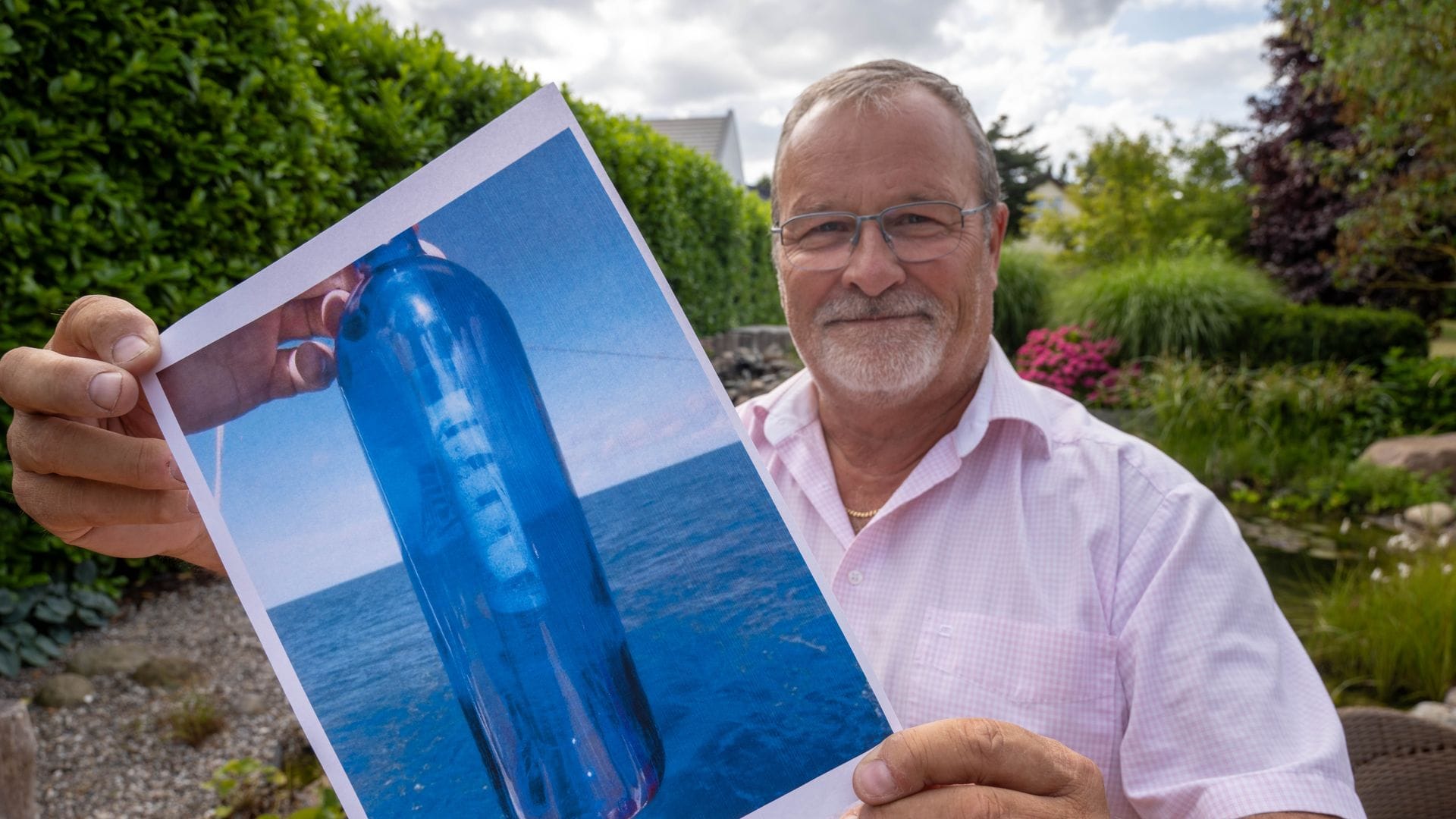 Jörg Wanke zeigt ein Foto seiner Flaschenpost.