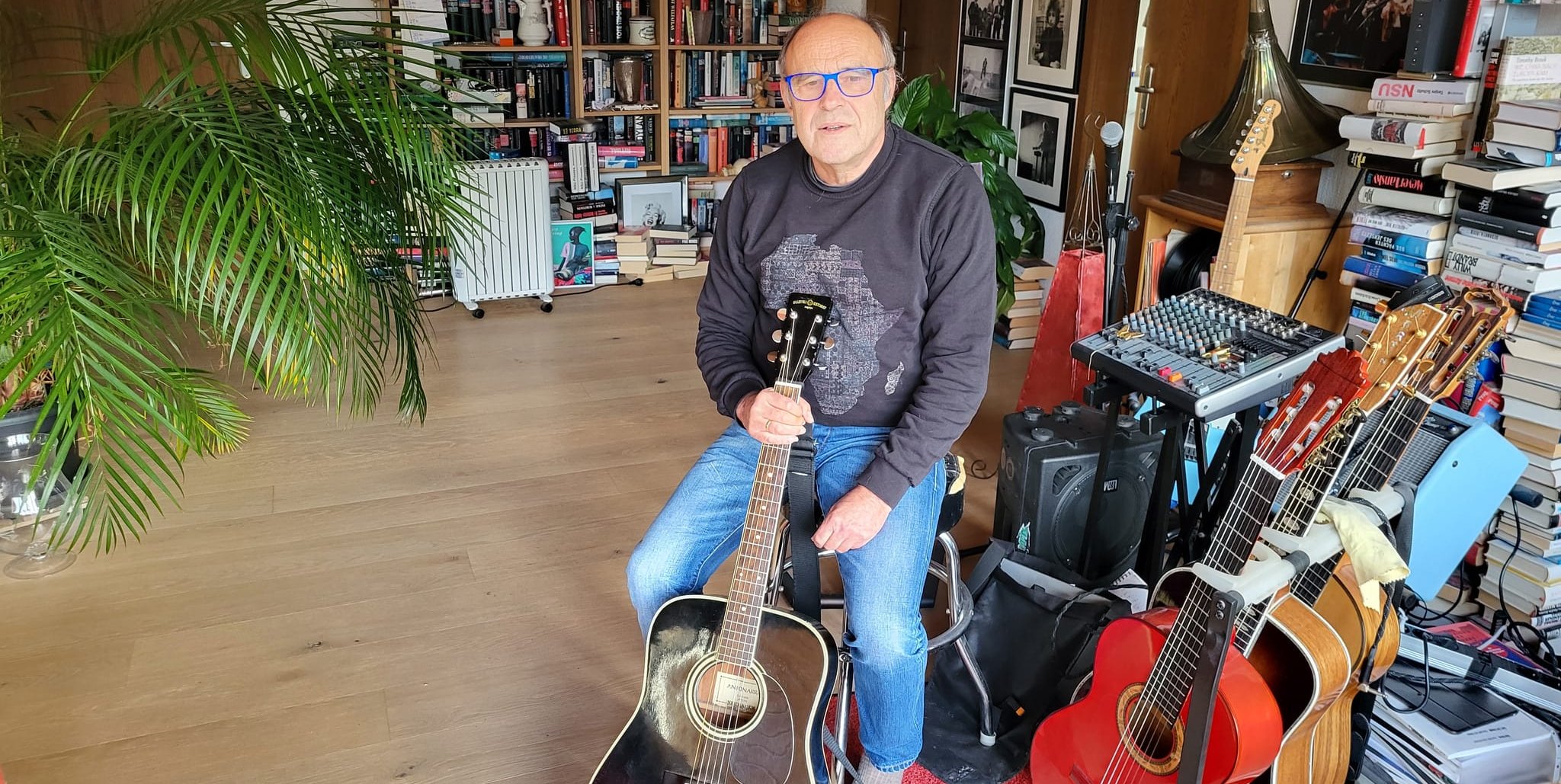 Manfred Müller mit der von einer SZ/BZ-Leserin gespendeten Gitarre  – daneben steht seine persönliche Sammlung.