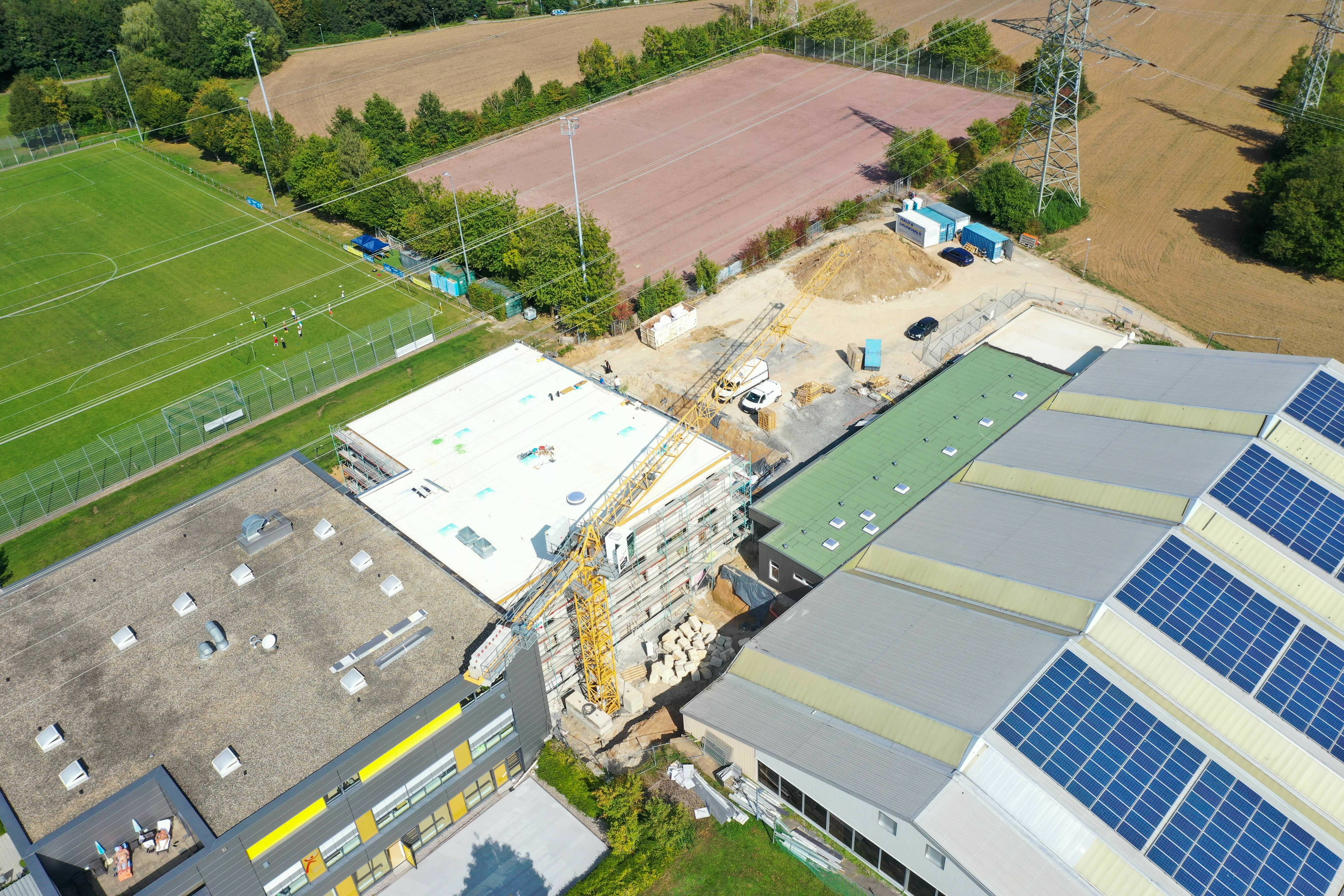 Die Sportwelt zwischen Fußballplatz und Tennishalle aus der Vogelperspektive. Links das bereits bestehende Gebäude, rechts die Erweiterung. Bild: Dettenmeyer