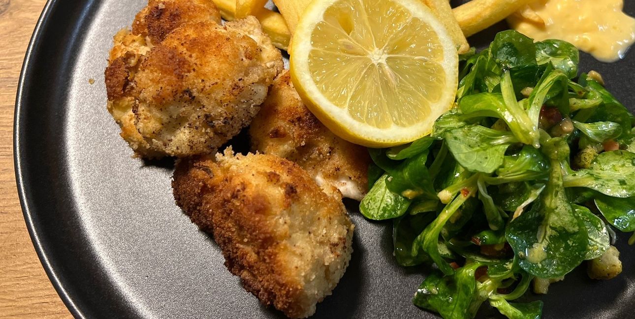Panierter Blumenkohl mit Pommes und Feldsalat.