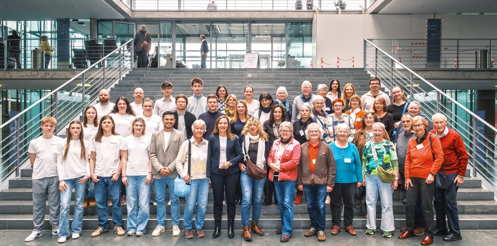 Jasmina Hostert mit ihrer Besuchergruppe aus dem Kreis Böblingen auf den Treppen im Bundestag.