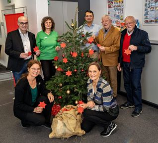 Weihnachtsbaumwunsch-Aktion in Grafenau. Beim Anbringen der Wunschsterne an den Weihnachtsbaum stehend von links Bürgermeister Martin Thüringer, Jutta Klasen und Tim Reinemann von der Kreissparkasse, Jürgen Matthiessen und Wolfgang Schmetzer von der Bürgerstiftung. Vor dem Baum links Kreissparkassen-Filialleiterin Isabella Stocklas und Patricia Wahl von der Bürgerstiftung.
