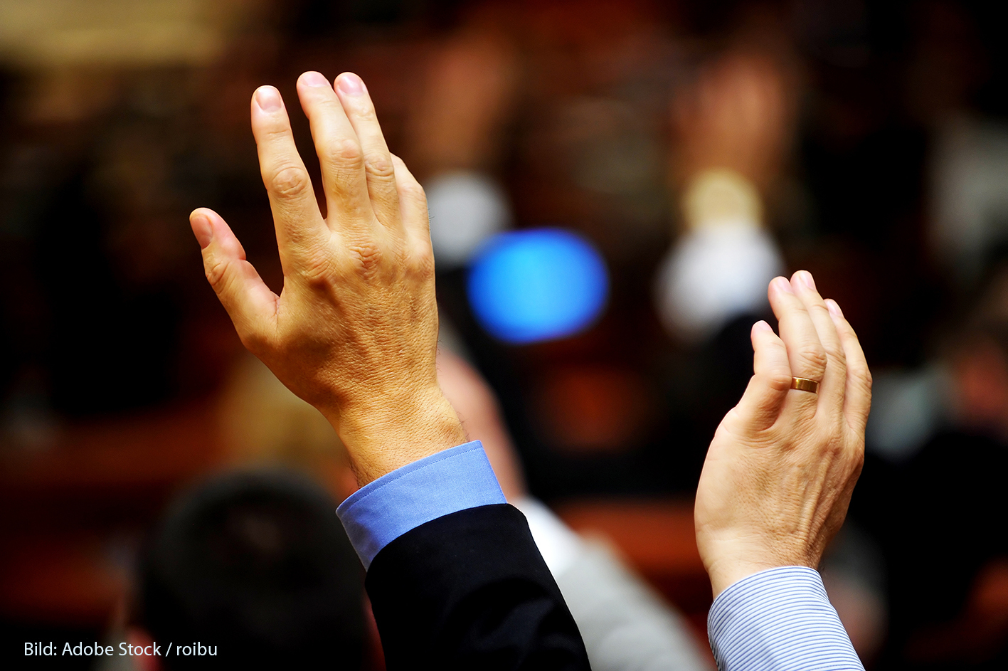 Detail shot with two raised hands expressing a vote
