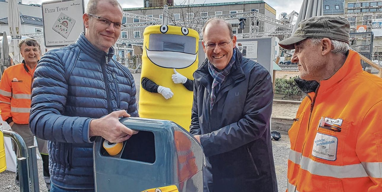 Dauerthema Müll: Dr. Bernd Vöhringer (Mitte) schraubt den ersten „Mülltoni 2.0“ am Grünen Platz an. Dazu gibt es Einzelheiten zur neuen Müllkampagne – unter anderem mit der Idee von ehrenamtlichen Aufpassern. Bild: Wegner