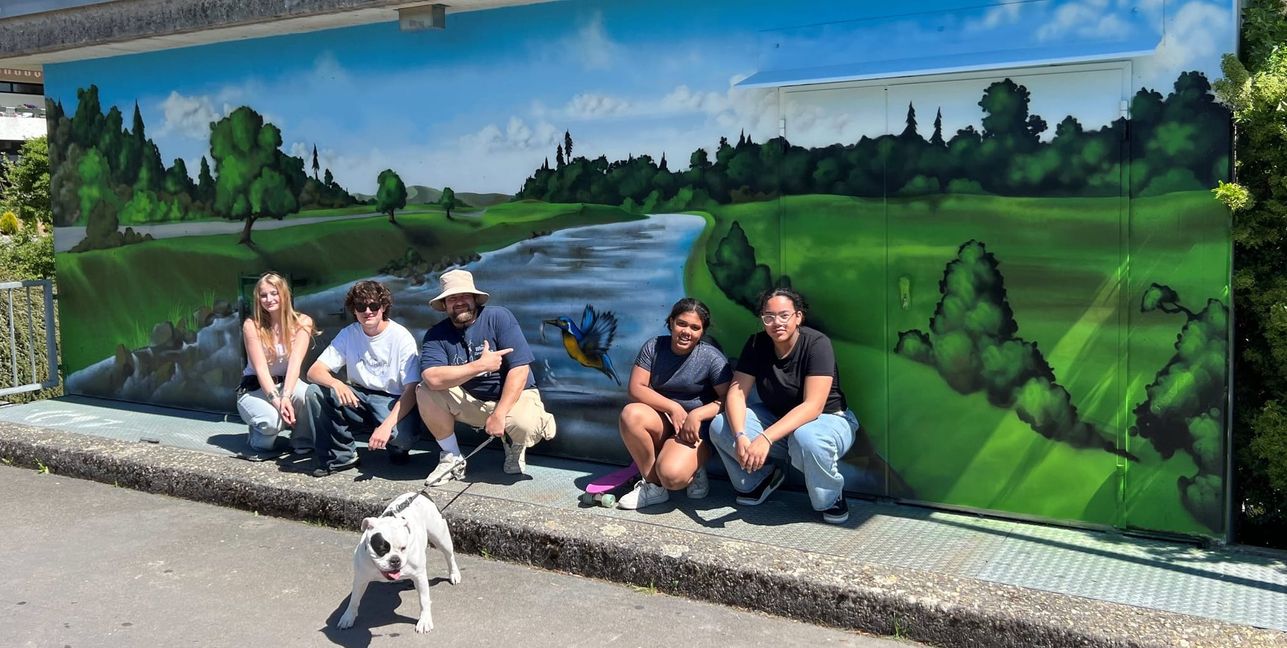 Auf dem Foto zu sehen ist der Künstler Maximilian Frank (Mitte) mit Jugendlichen vor dem Graffiti-Kunstwerk. Bild: Landratsamt