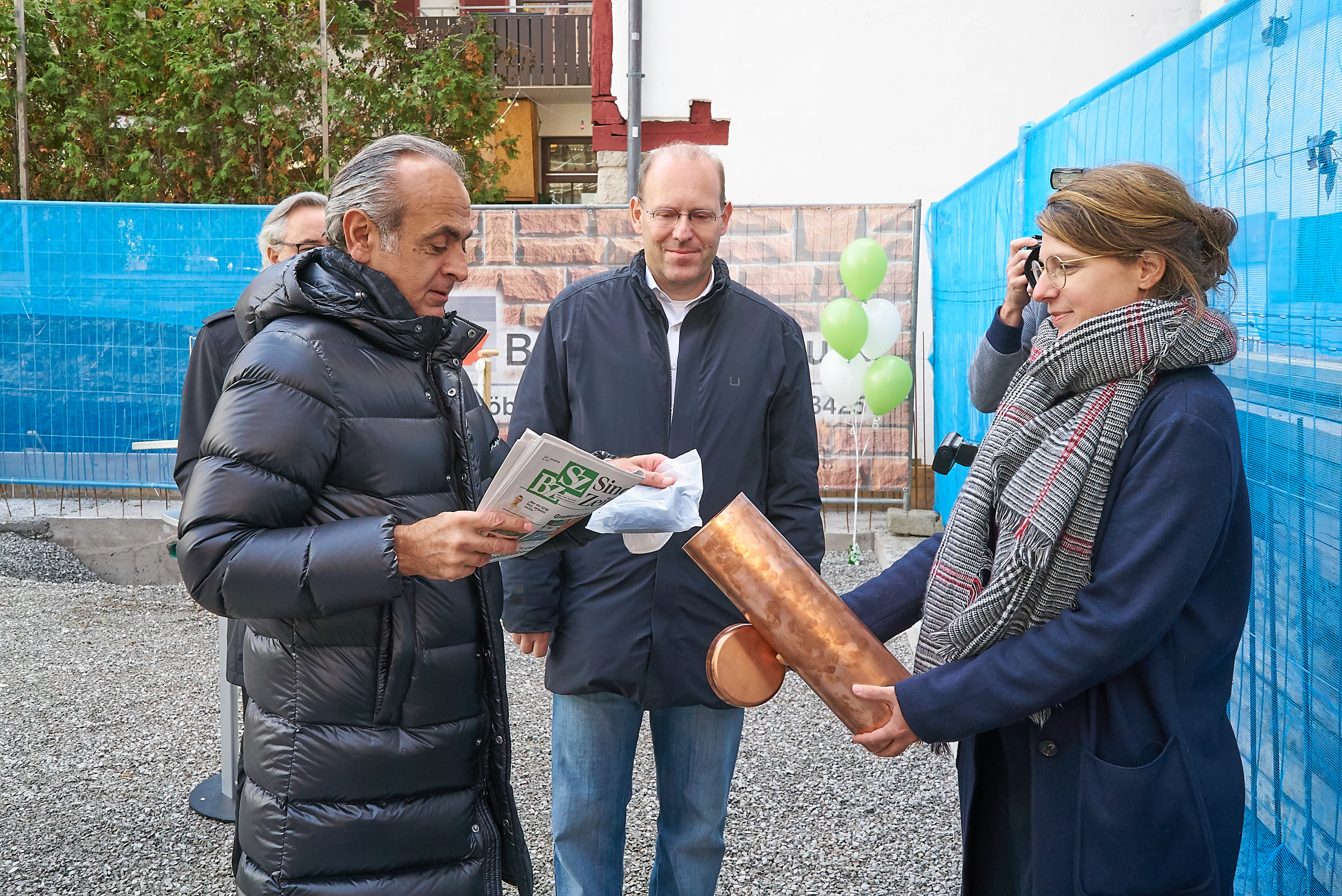 Wohnstätten-Chef Georgios Tsomidis packte auch eine Ausgabe der SZ/BZ in die von Tina Seiberts gehaltene Zeitkapsel für den Grundstein. OB Dr. Bernd Vöhringer schaut zu.