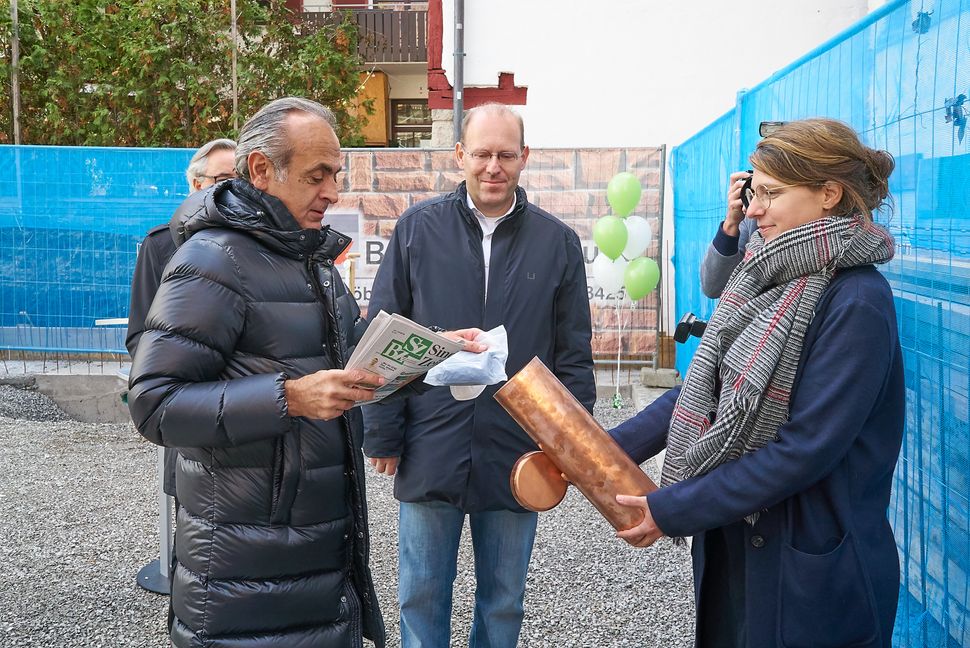Wohnstätten-Chef Georgios Tsomidis packte auch eine Ausgabe der SZ/BZ in die von Tina Seiberts gehaltene Zeitkapsel für den Grundstein. OB Dr. Bernd Vöhringer schaut zu.