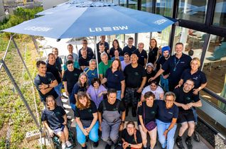 Beschäftigte der GWW und Mitarbeiter der LBBW freuen sich über die neuen Sonnenschirme für die Werkstatt Sindelfingen.
