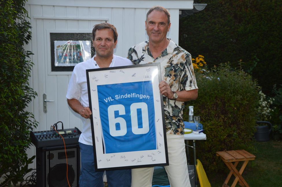 VfL-Abteilungsleiter Carsten Seeger überraschte Werner Bacher mit einem besonderen Geschenk. Bild: Holzapfel