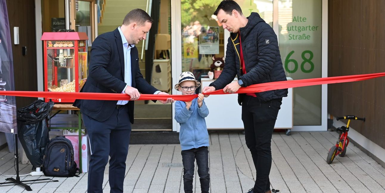 Assistiert von Bürgermeister Florian Glock (links) und Kindergartenleiter Michael Schultz durchschneidet der sechsjährige Paul bei der Einweihung das Band und macht so den Weg frei in den Kindergarten Gollenberg. Der Junge war vor drei Jahren das erste Kind, das für diesen Kindergarten angemeldet wurde.       Bild: Reichert