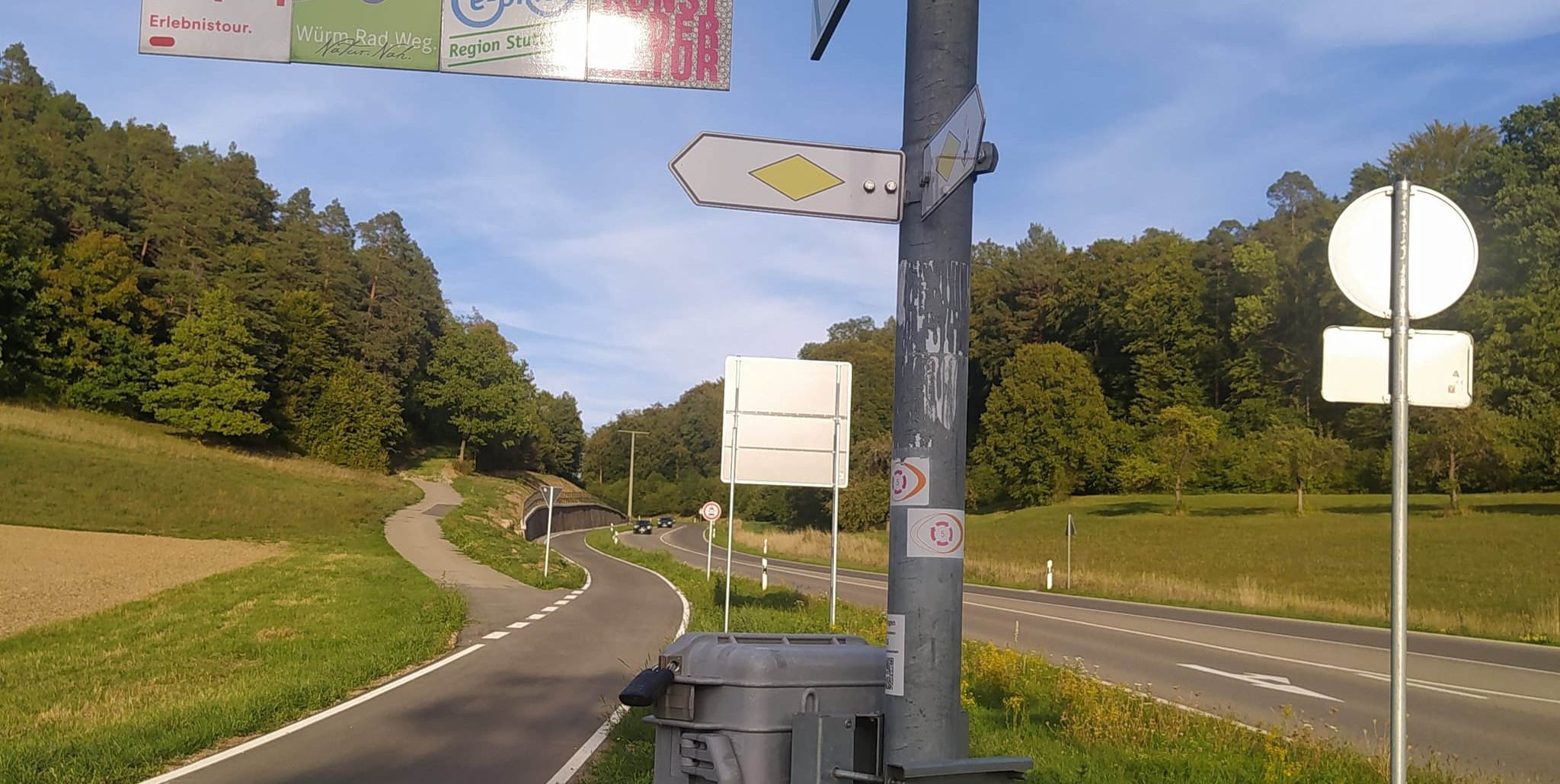 Das graue Kästchen unter den Wegzeigern enthält ein Zahlwerk, das die Nutzung des Radwegs an der Aidlinger Kehle erfasst. Bilder: Reichert