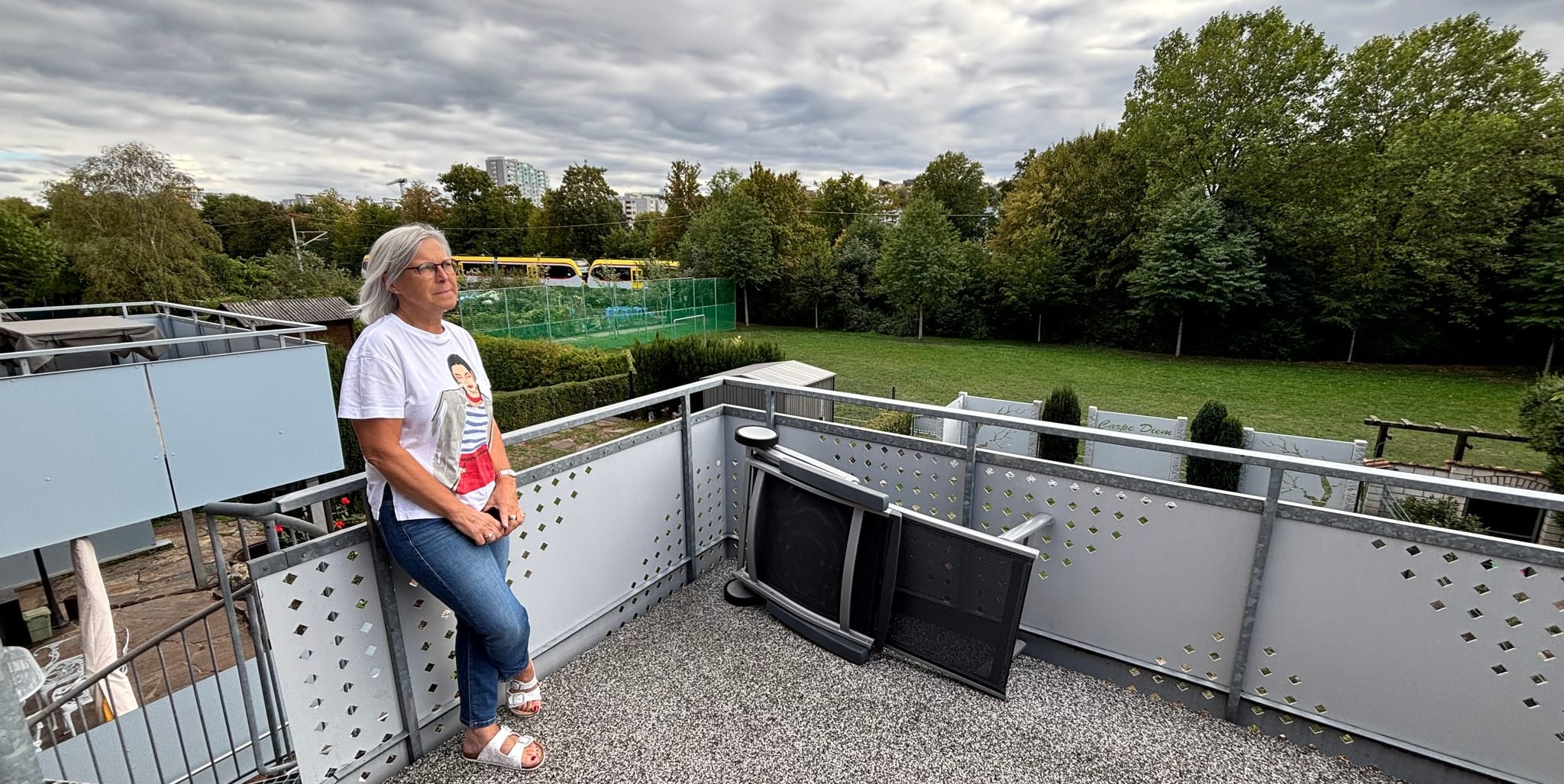 Petra Wolf auf ihrem Balkon im Häuserweg - im Hintergrund fährt die Schönbuchbahn.