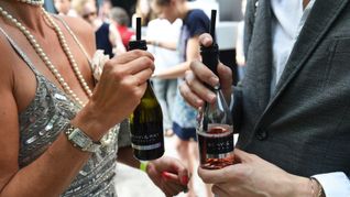 Small Talk mit Prosecco: Gäste unterhalten sich am Rande einer Modenschau in Berlin. (Archivbild)