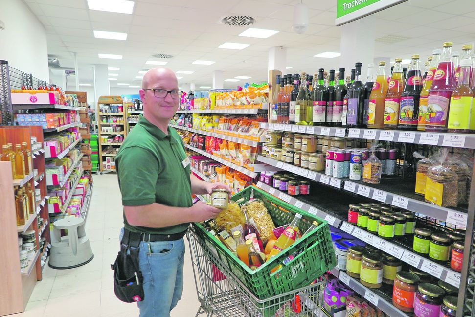 Der Herrenberger Marktleiter Steffen Rau beim Befüllen eines Warenkorbes mit regionalen Produkten. Bild: Groß