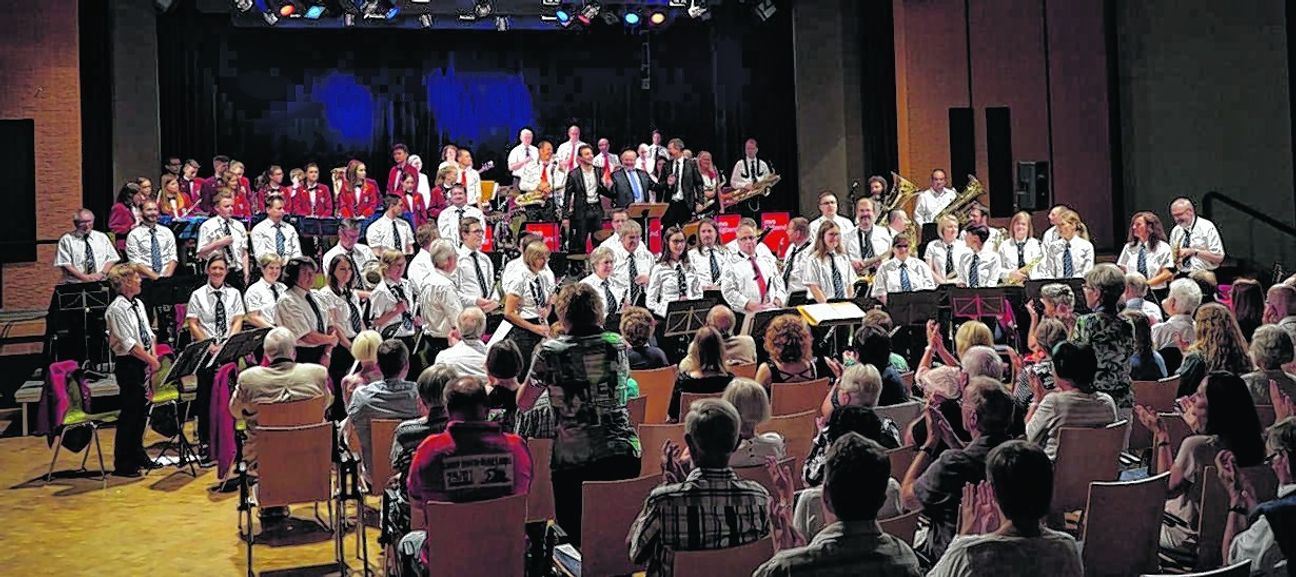 Mittendrin im schwarzen Anzug: Big-Band-Sänger Alexander Wolff, Big-Band-Dirigent Jörg Gebhardt und Stadtmusikdirektor Markus Nau mit ihren Ensembles im Bürgerhaus Maichingen. Bild: Heiden