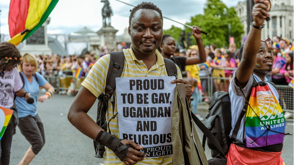 Auf einer Demonstration für die LGBTQIA+-Gemeinschaft 2022 in London trägt ein Teilnehmer ein Plakat mit der Aufschrift: „Stolz schwul, Ugander und religiös zu sein“.
