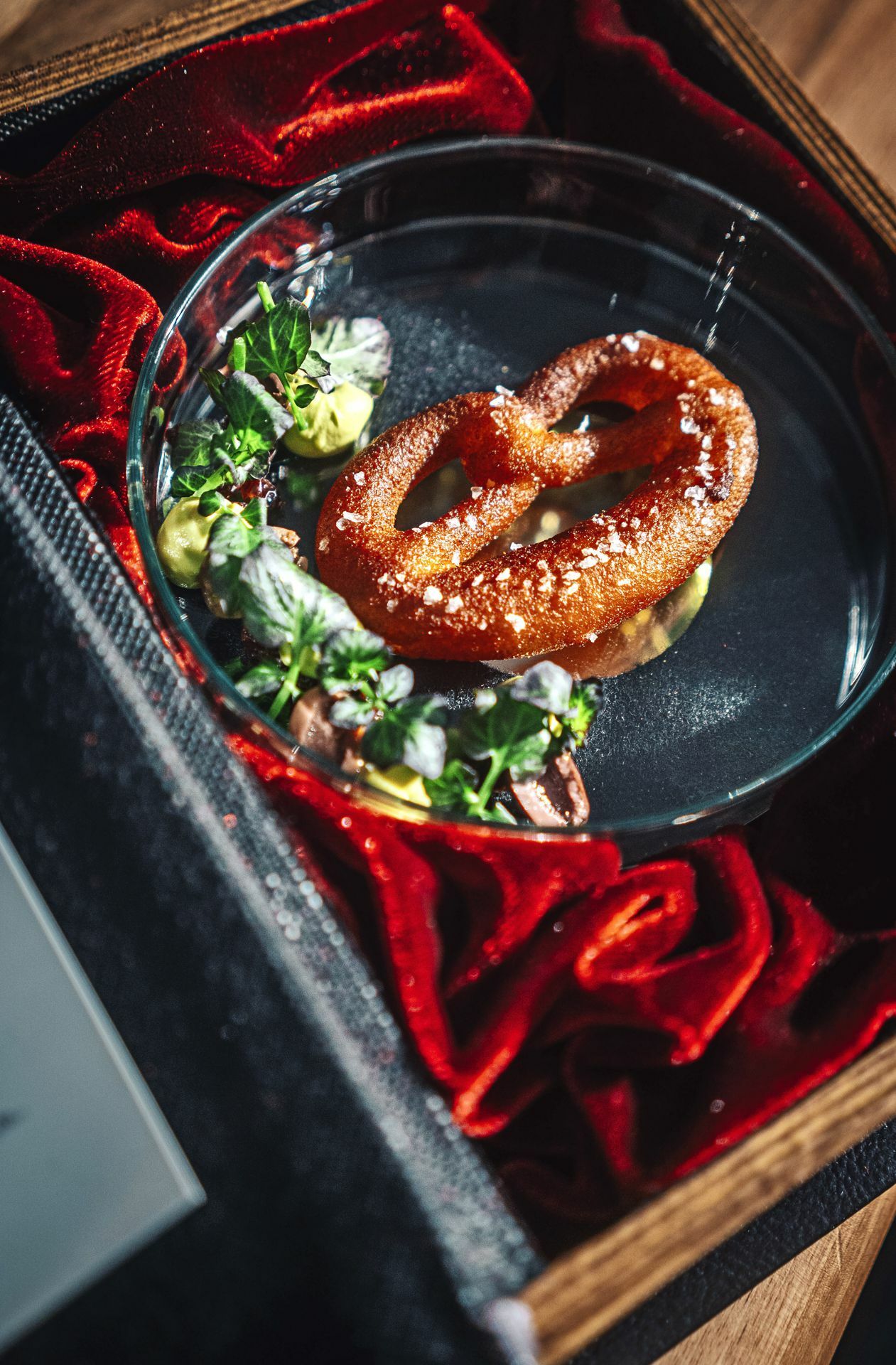 Die Brezel wird in einer Art Buch serviert, beleuchtet ist sie außerdem und eine Geschichte erklärt ihre Herkunft in Bad Urach.