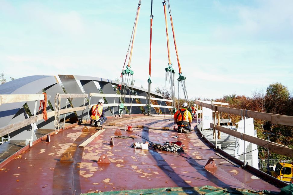 Die neue Radweg-Brücke wird an ihren Platz über der Panzerstraße gehoben.