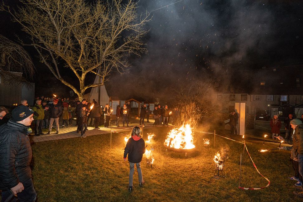 Nach der Andacht in der Waldenserkirche in Neuhengstett geht es mit Fackeln zum Museum, wo im Garten eine Feuerschale entzündet wurde.           Bild: Richter