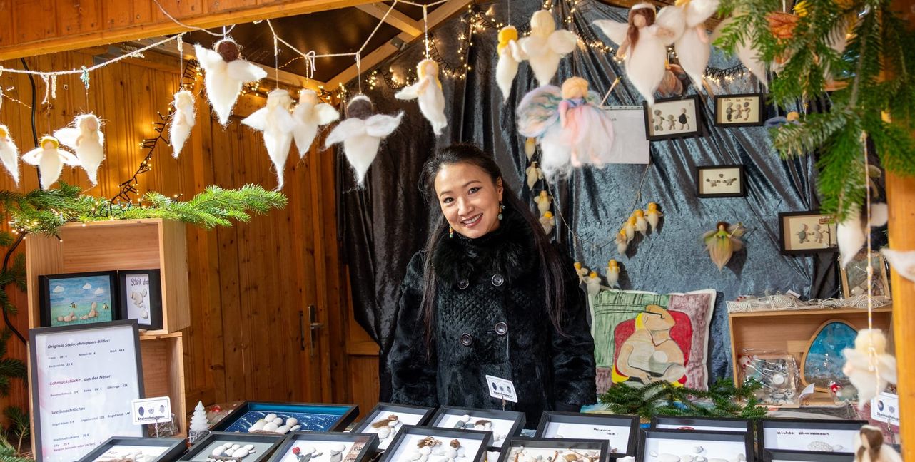 Junjie Gottschalk an ihrem Stand mit Steinschuppenbildern und Engelchen.