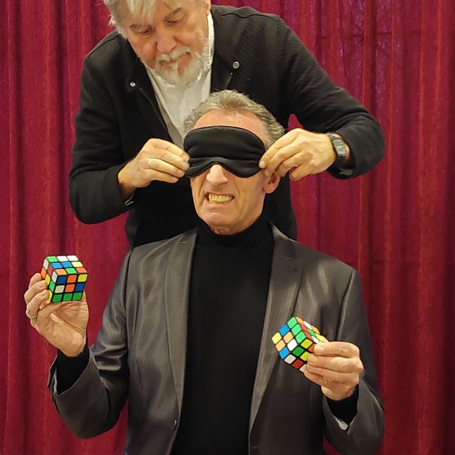 Mit verbundenen Augen versucht Andy Häussler, zeitgleich zwei Zauberwürfel, einen mit der linken Hand, einen mit der rechten Hand, zu lösen.   Bild: Oberdorfer