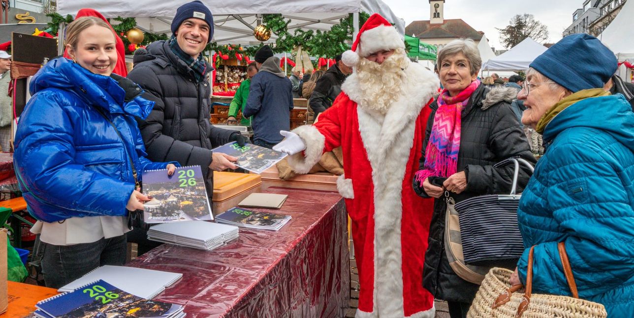 Emily Henne, Auszubildende bei Röhm-Medien, SZ/BZ-Verleger Dr. Christian Röhm und SZ/BZ-Redakteur Dennis Klemm als Nikolaus verteilen den Jahreskalender 2026 an Abonnenten.