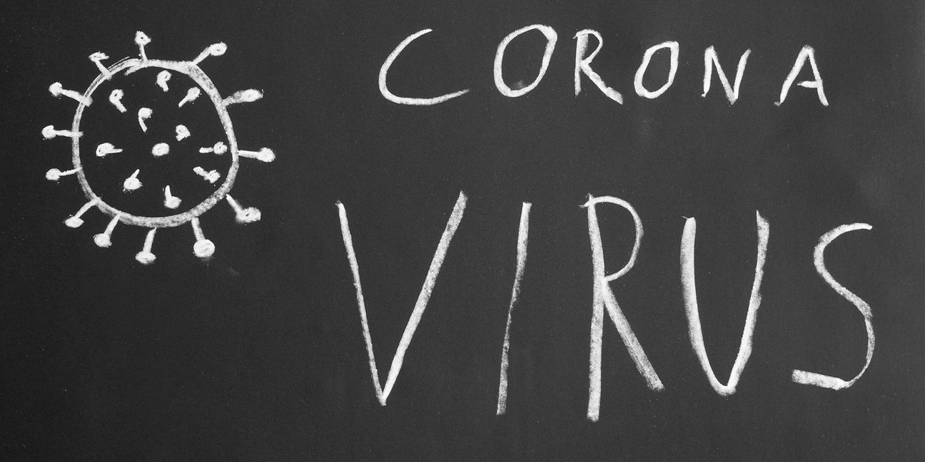 Corona virus hand-drawn text and simple illustration with chalk on blackboard