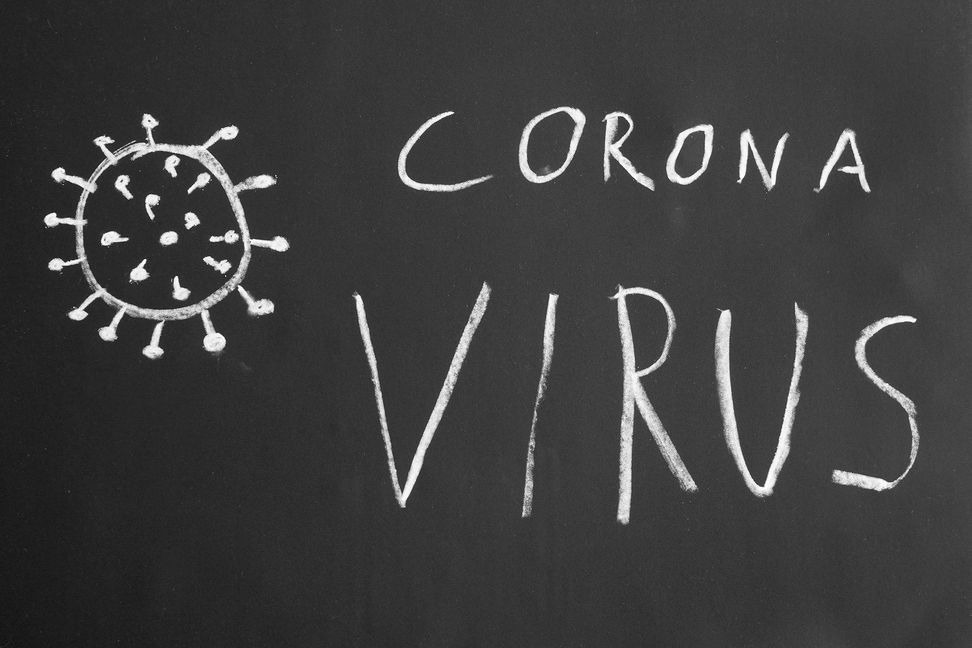 Corona virus hand-drawn text and simple illustration with chalk on blackboard
