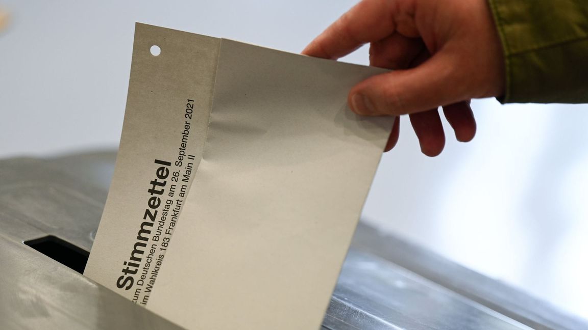 Ein Mann steckt den Stimmzettel für die Bundestagswahl 2021 ein.