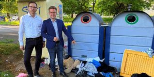 Dr. Markus Fritz und Max Reinhardt vor einem Altkleidercontainer mit wildem Müll in der Pfarrwiesenallee.