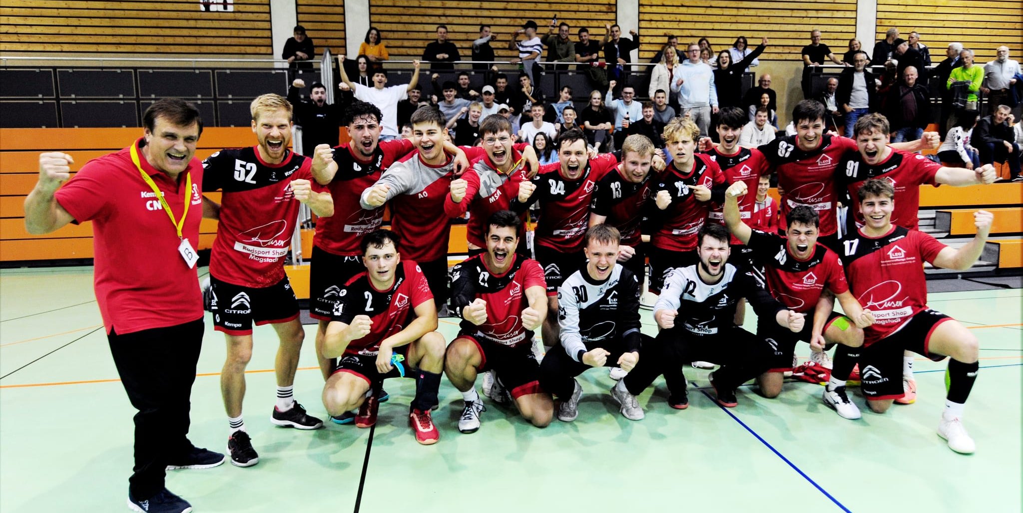 Trainer Costica Neagu (iinks) und die Handballer des SV Magstadt feiern den ersten Saisonsieg in der Bezirksoberliga.