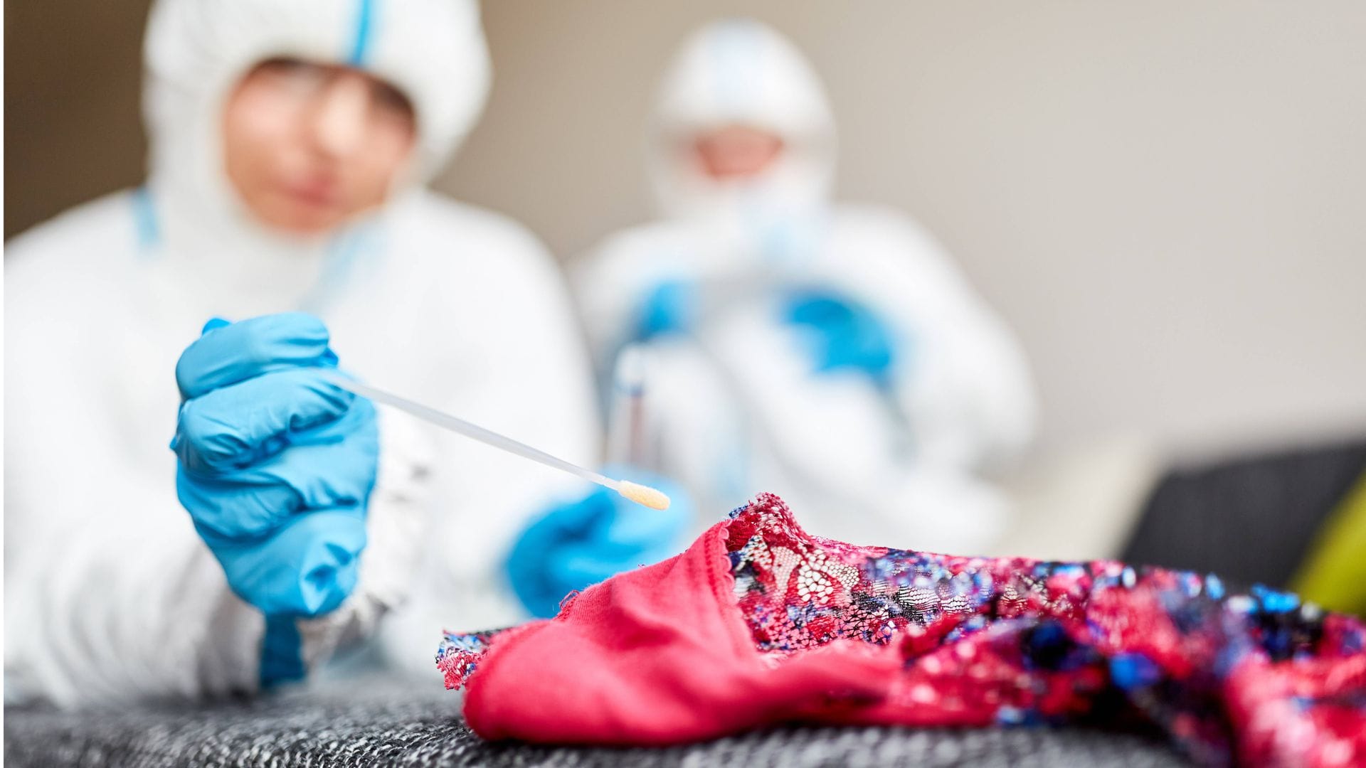 Forensiker nehmen eine DNA-Probe an Unterwäsche  nach einer Vergewaltigung (gestellte Szene).