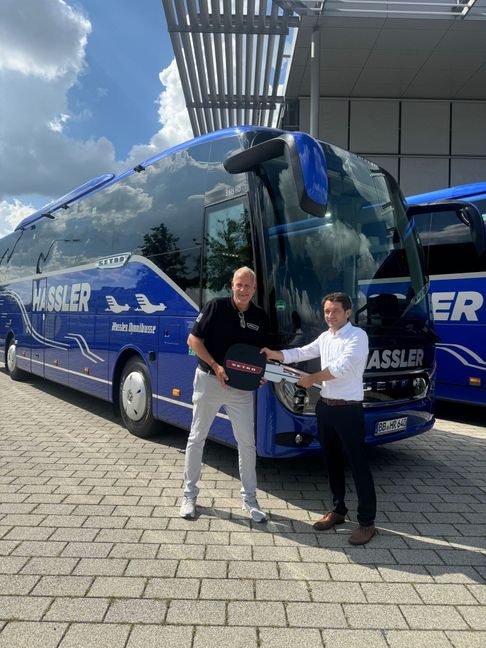 Dominik Hassler (rechts), Geschäftsführer von Hassler-Reisen nimmt den symbolischen Schlüssel in Übergröße von Setra General Vertreter Andreas Losert entgegen.