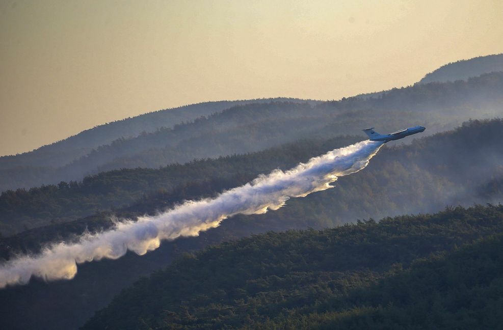 Ein Löschflugzeug der türkischen Streitkräfte wirft über einem Waldbrand in der Provinz Mugla im Süden der Türkei Wasser ab.
 Foto: AP