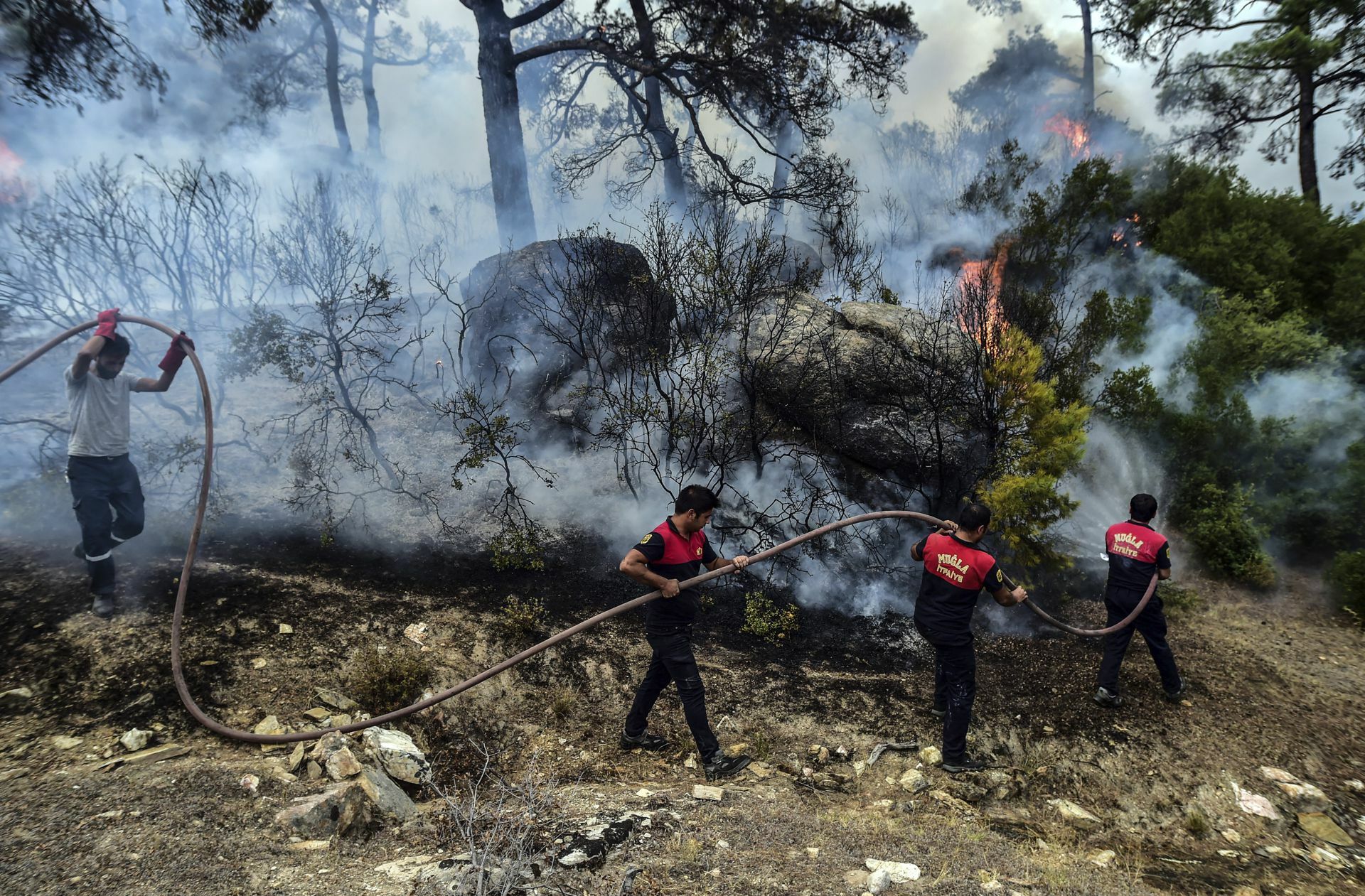 Feuerwehrleute löschen einen Brand in der türkischen Provinz Mugla.
 Foto: IHA/AP