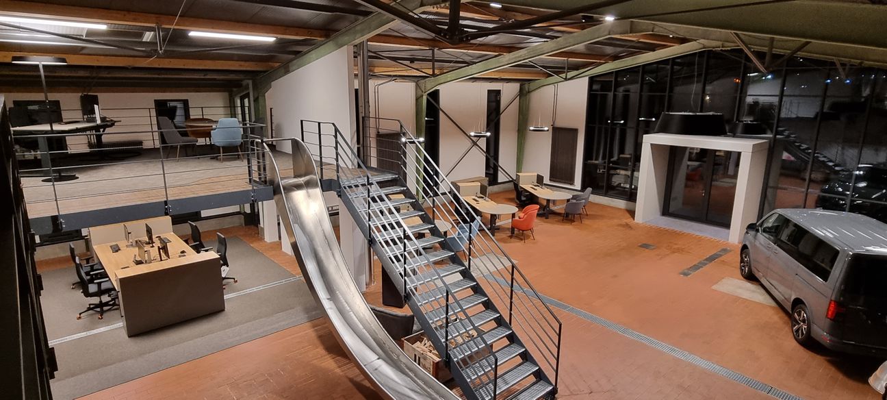 Ein echter Hingucker ist das Maisonnette-Büro mit Rutsche, die auf den alten Werktstt-Boden aus Stein führt.