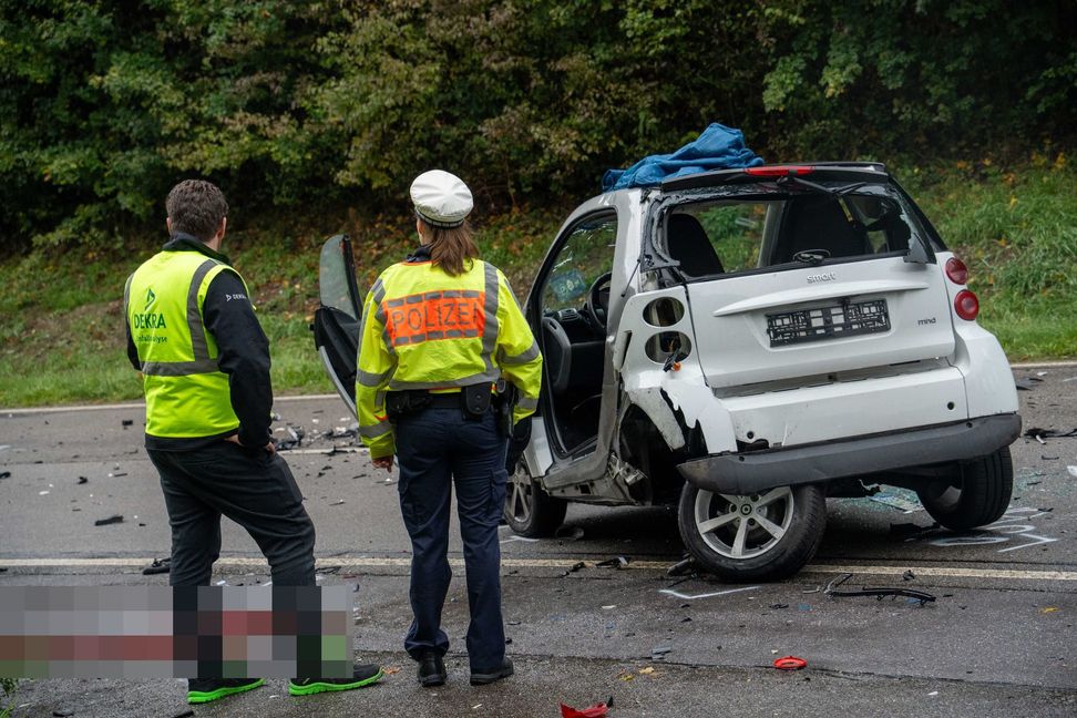 Die beiden Helfer stehen fassungslos vor dem völlig demolierten Smart des 21-jährigen Fahrers. Bild: SDMG/Dettenmeyer