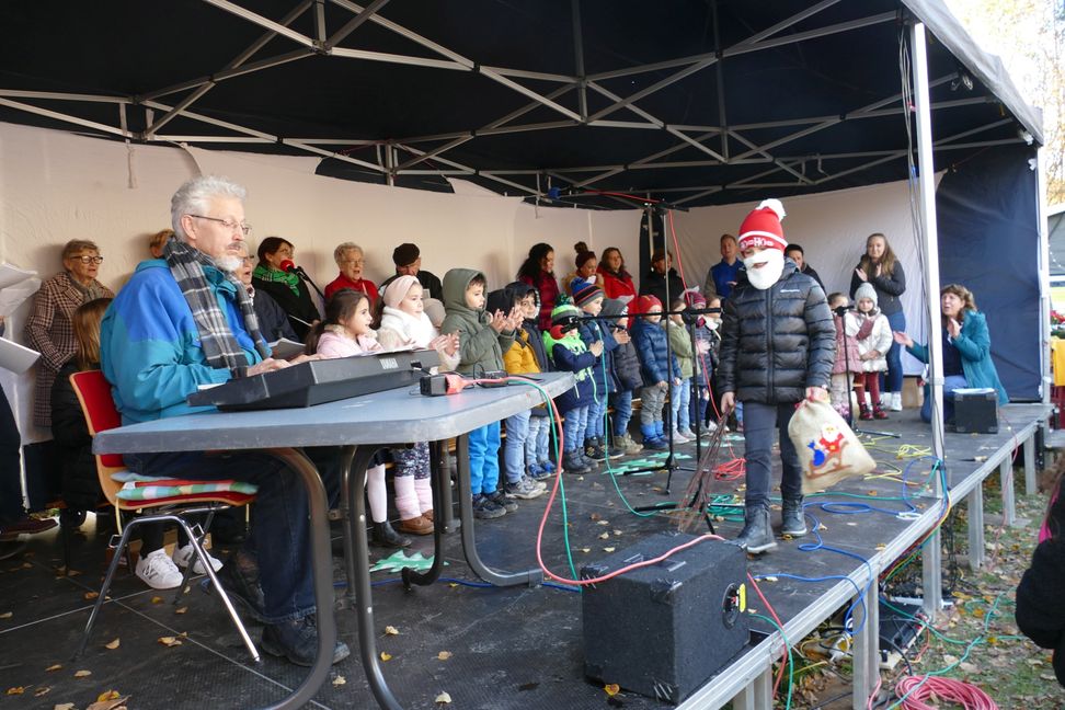 Kinder des Hummel-Familienzentrums, deren Eltern und der Insel-Singkreis stimmten unter der Leitung von Martina Hecht im Eichholz auf den Advent ein. Bild: Lück