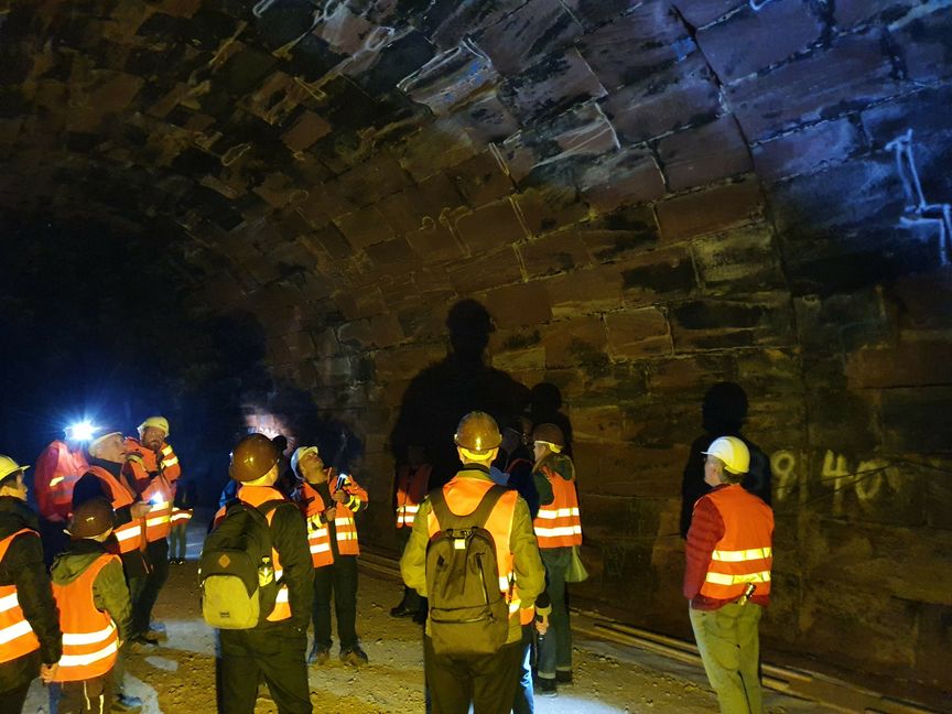 Holger Schwolow (Mitte, mit Taschenlampe) vom Zweckverband Hermann-Hesse-Bahn erläutert die Sanierungsarbeiten am Hirsauer Tunnel. Foto: Knupfer