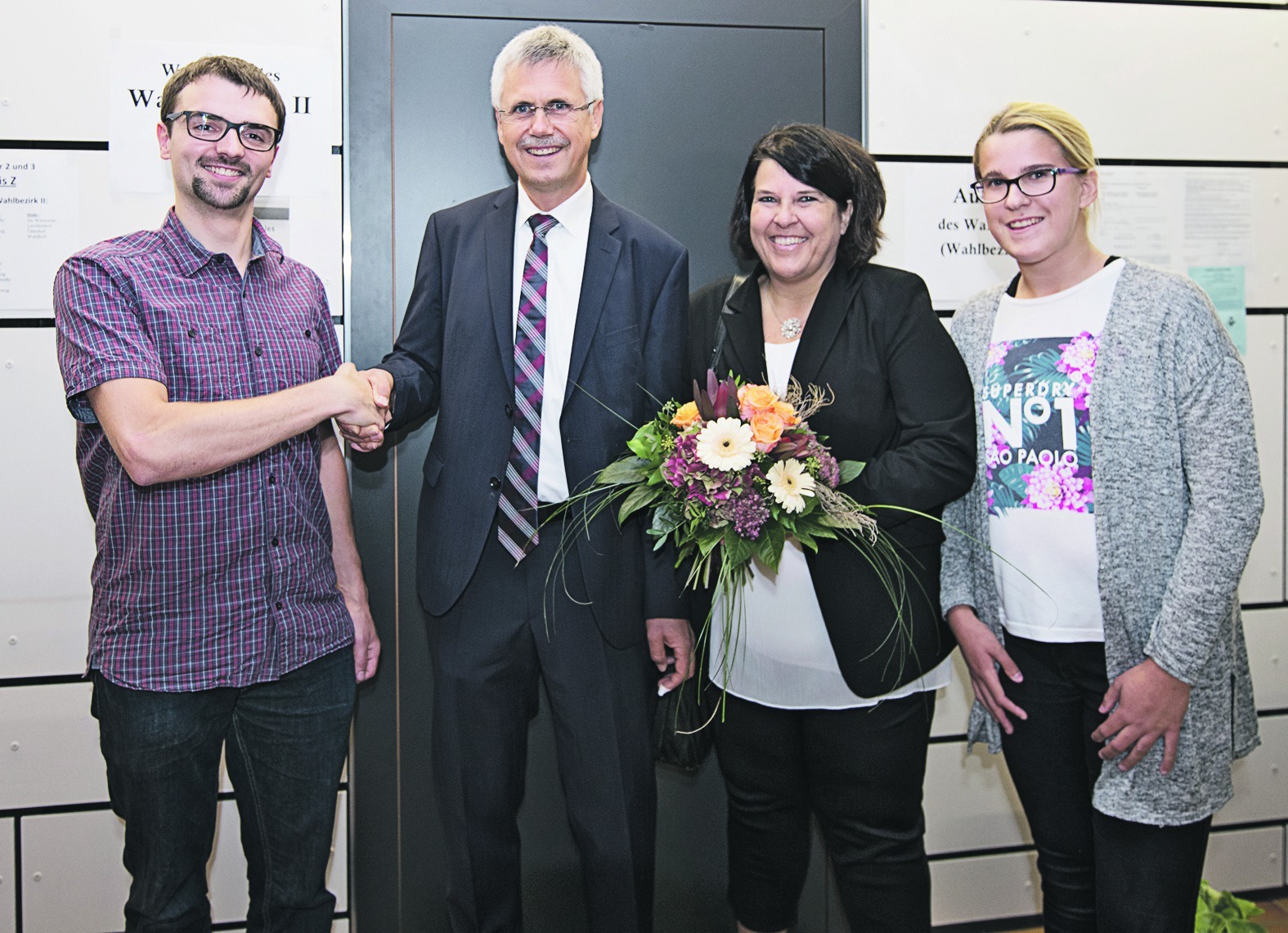 Der stellvertretende Bürgermeister Simon Klass (links) gratuliert Jens Häußler zur Wiederwahl in Gechingen. Daneben Frau Claudia und Tochter Janina.  Bild: Richter
