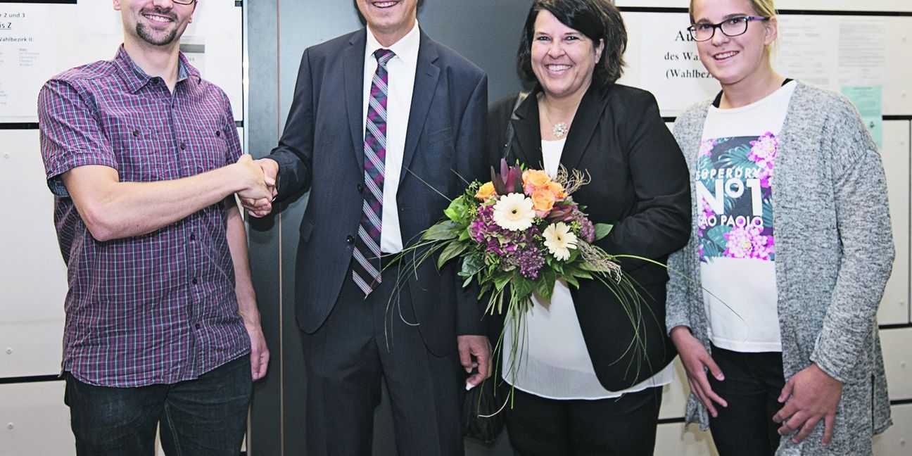 Der stellvertretende Bürgermeister Simon Klass (links) gratuliert Jens Häußler zur Wiederwahl in Gechingen. Daneben Frau Claudia und Tochter Janina.  Bild: Richter