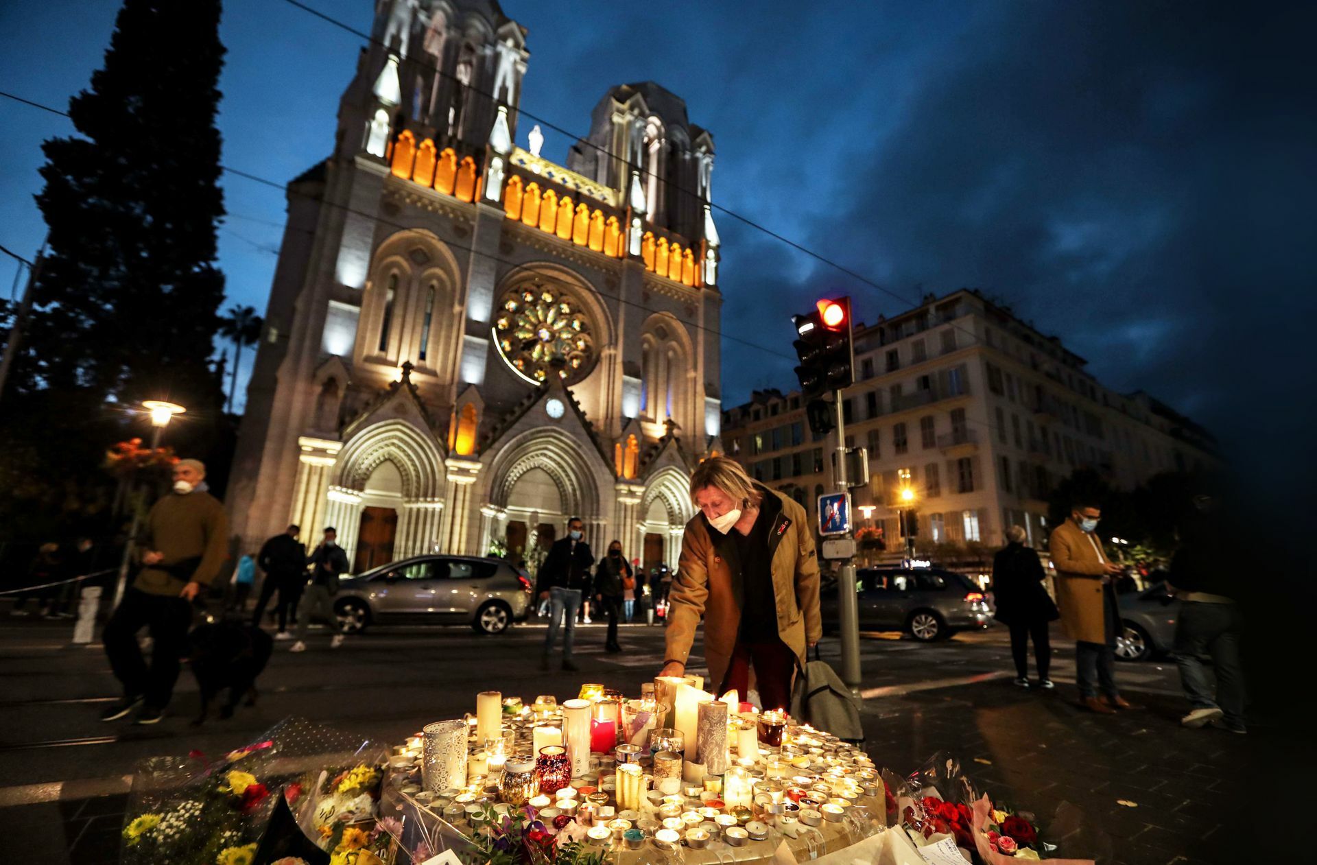 Eine Frau zündet eine Kerze vor der Basilika in Nizza an, wo am 29. Oktober eine Messerattacke stattfand.