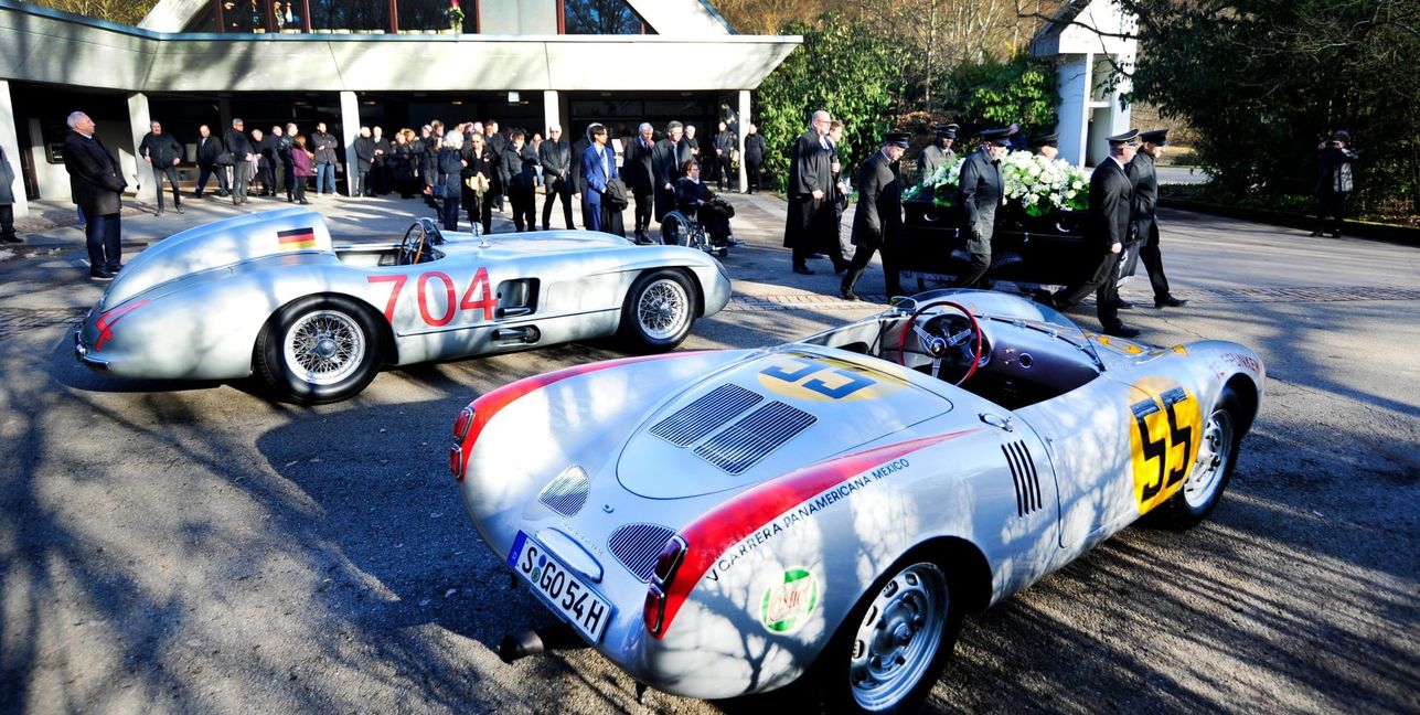 Hans Herrmanns letzter Weg vobei an zwei seiner legendären Rennwagen, einem Mercedes „Silberpfeil“ 300 SLR und ein Porsche 550. Bild: Photostampe