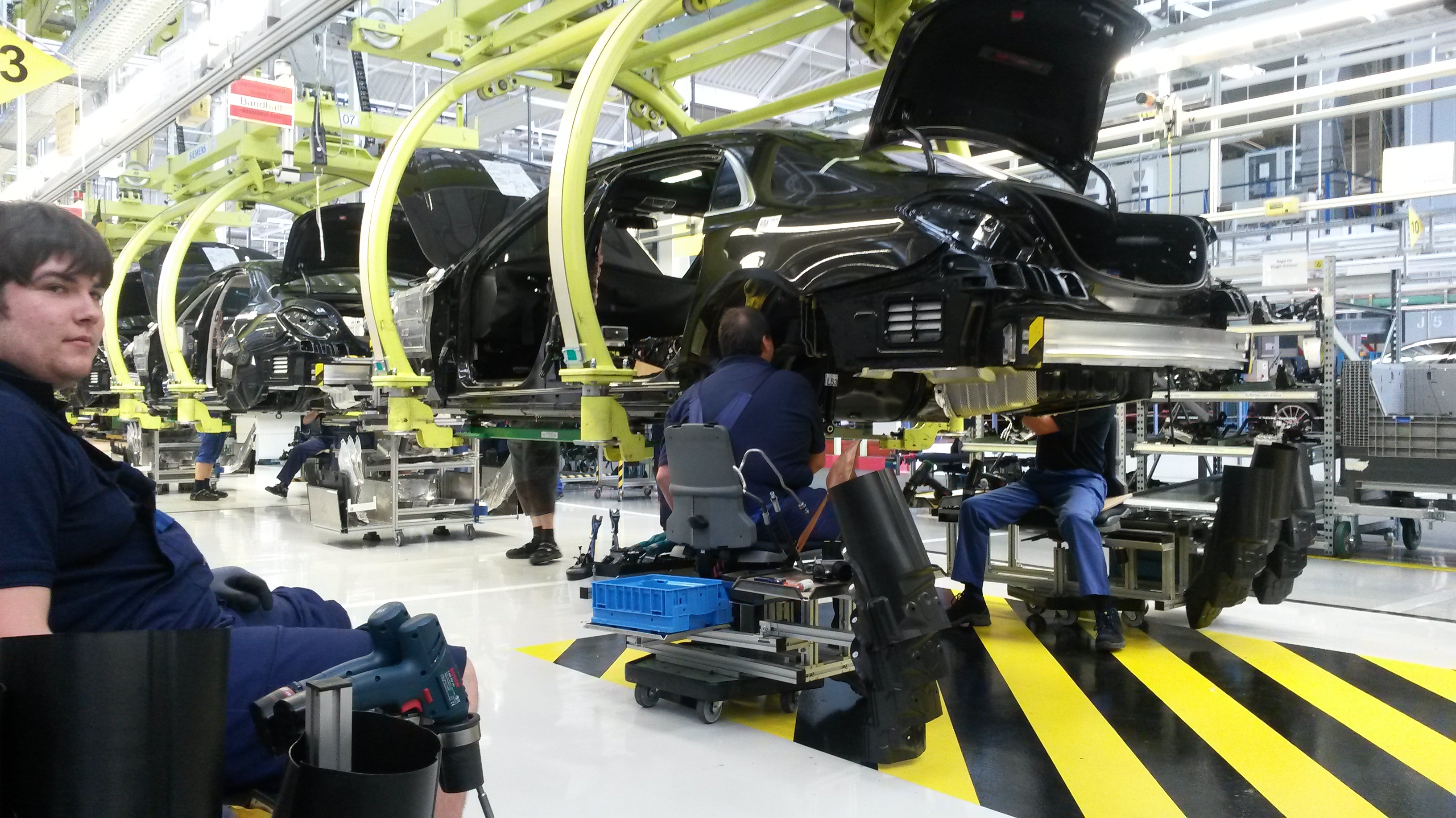 Ein Beispiel aus der S-Klasse-Produktion, das der Betriebsratsvorsitzende Ergun Lümali gerne als Standard in allen Montagestraßen hätte: Der Mitarbeiter fährt im Schlitten zum Wagen, der am schwenk- und höhenverstellbaren Haken hängt. Bild: Wegner