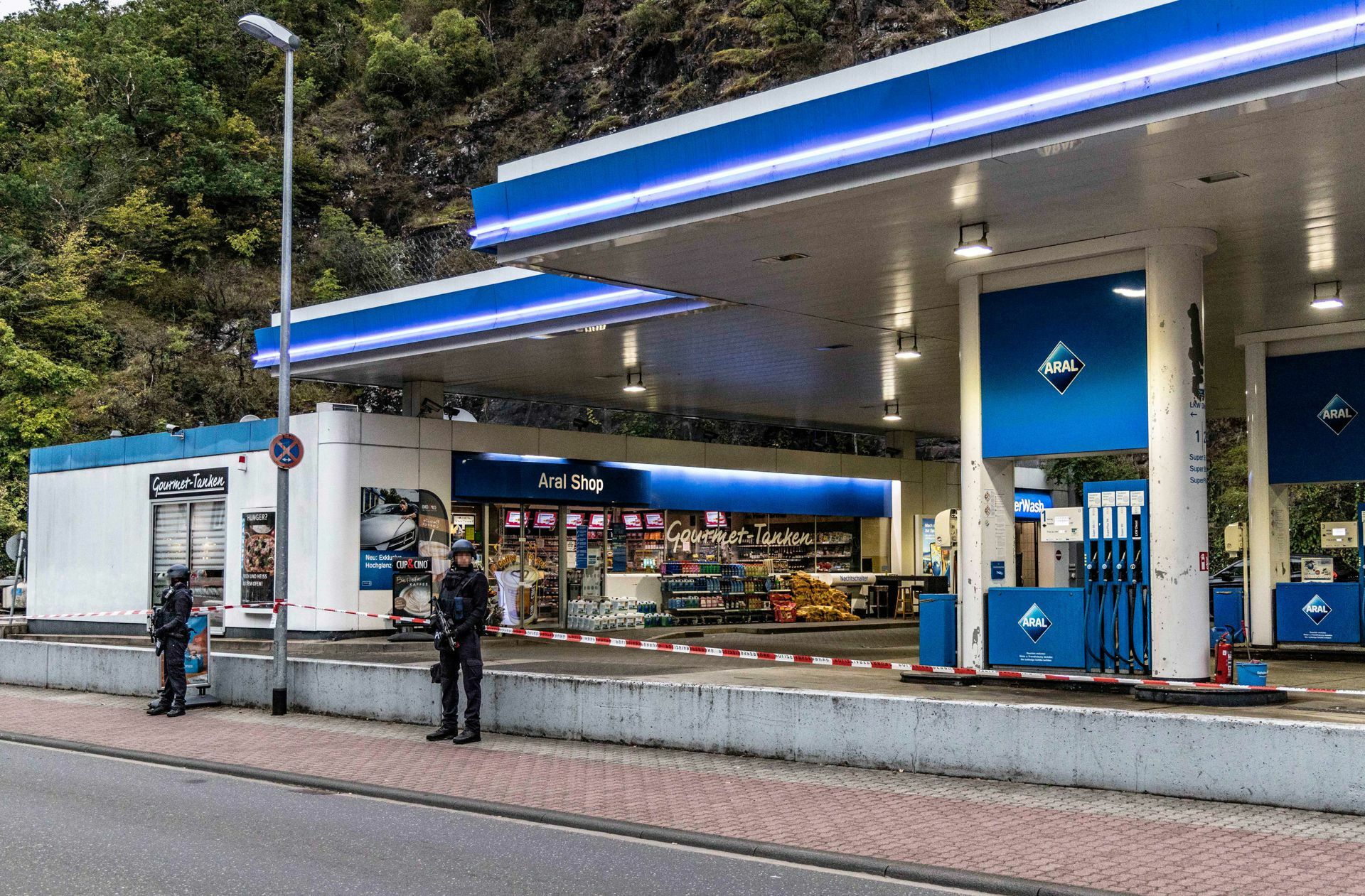 Polizisten sichern am frühen Morgen eine Tankstelle, in der am Vortag ein  49-Jähriger einem 20 Jahre alten Kassierer in den Kopf geschossen hatte.